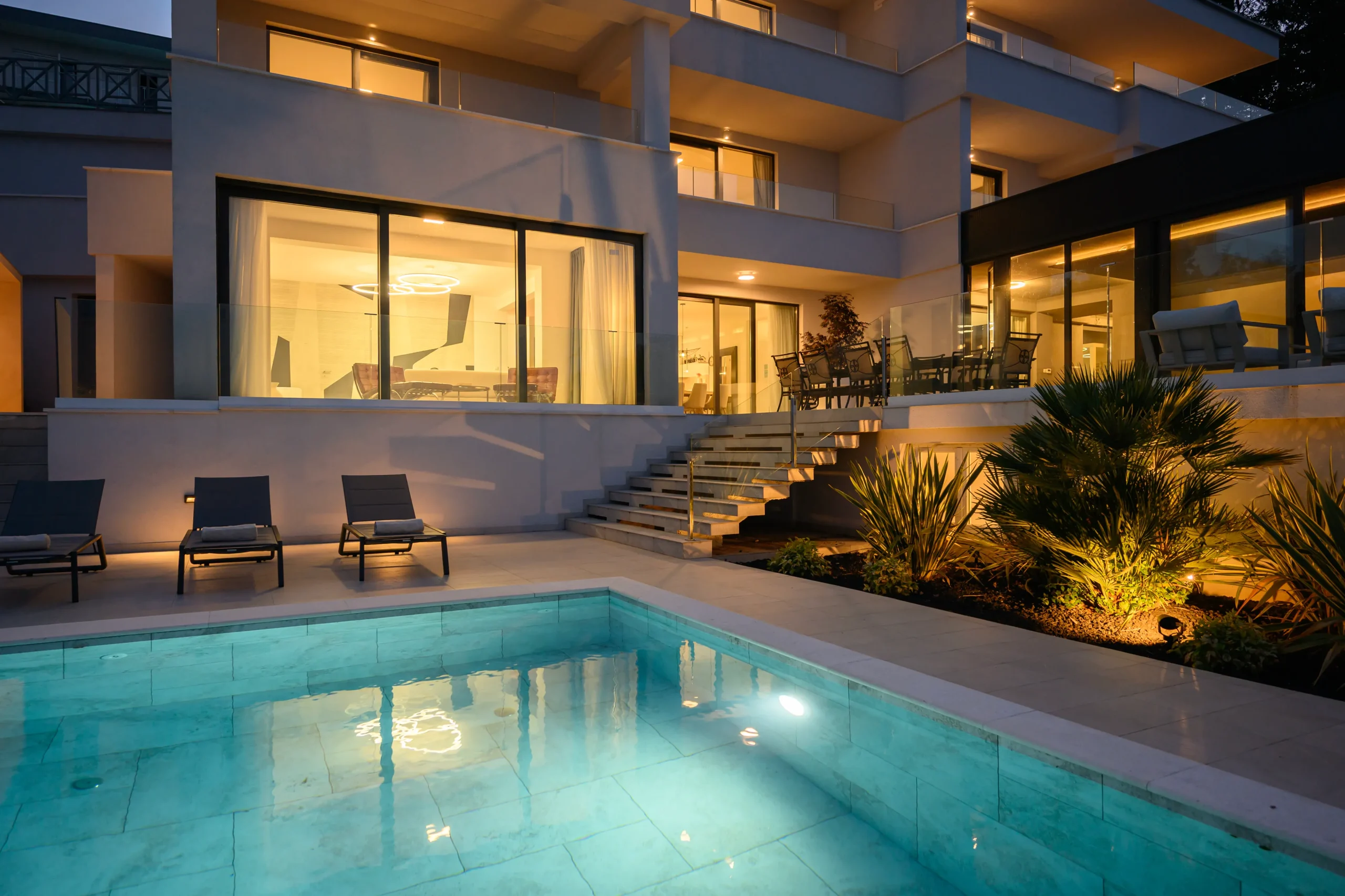 Villa Theodor's illuminated exterior, staircase and landscaped garden lighting at night